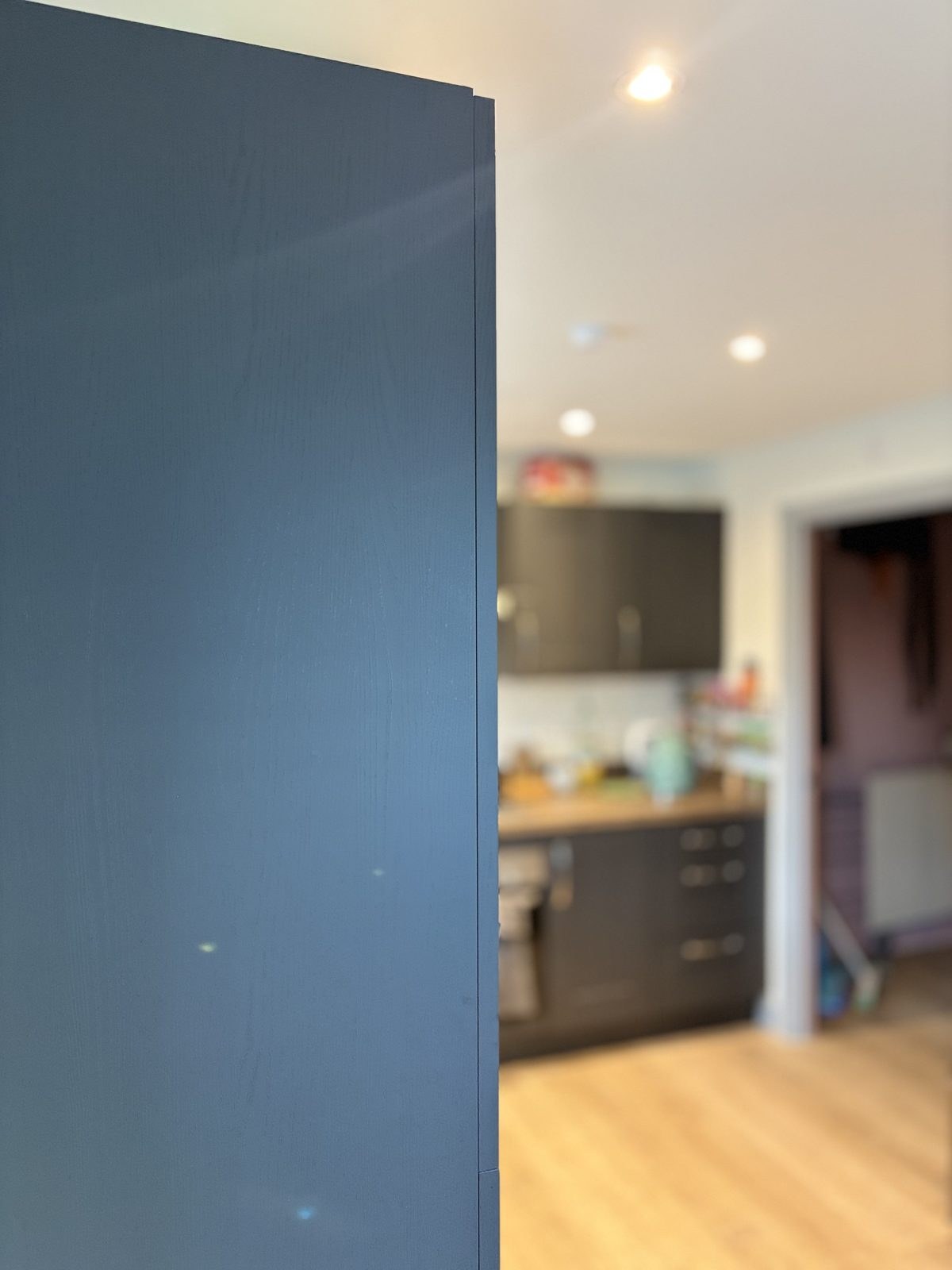 Black wood grain architectural film finish specified for kitchen cabinetry