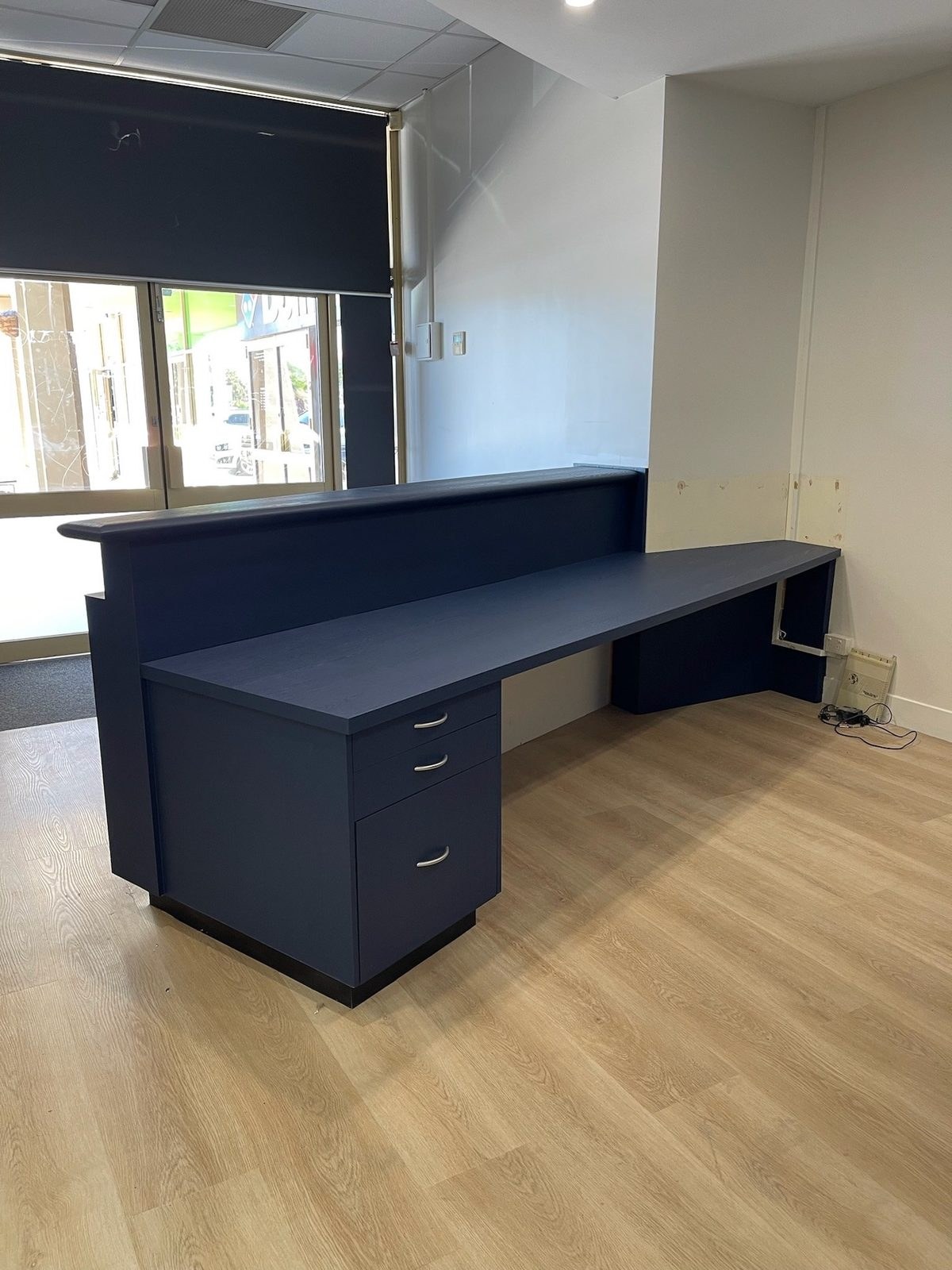 Reception desk wrapped in navy blue architectural film